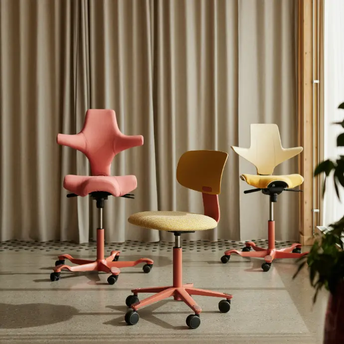 Capisco 8106, Tion 2140 and Capisco Puls 8020 in blush with Kvadrat upholstery Three HÅG chairs with blush frames: on the left Capisco 8106 in Kvadrat Steelcut Quartet 0534, in the middle Tion 2140 with Harvest shell and Kvadrat Sisu 0405, on the right Capisco Puls 8020 with Sand shell and Kvadrat Steelcut Quartet 434