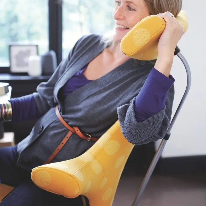 HÅG Capisco 8107 met hoofdsteun en Väveriet Snowball 1099 – ergonomisch comfort en optimale ondersteuning HÅG Capisco 8107 met Väveriet Snowball 1099 bekleding – vrouw leunt ontspannen op de hoofdsteun voor extra ondersteuning.