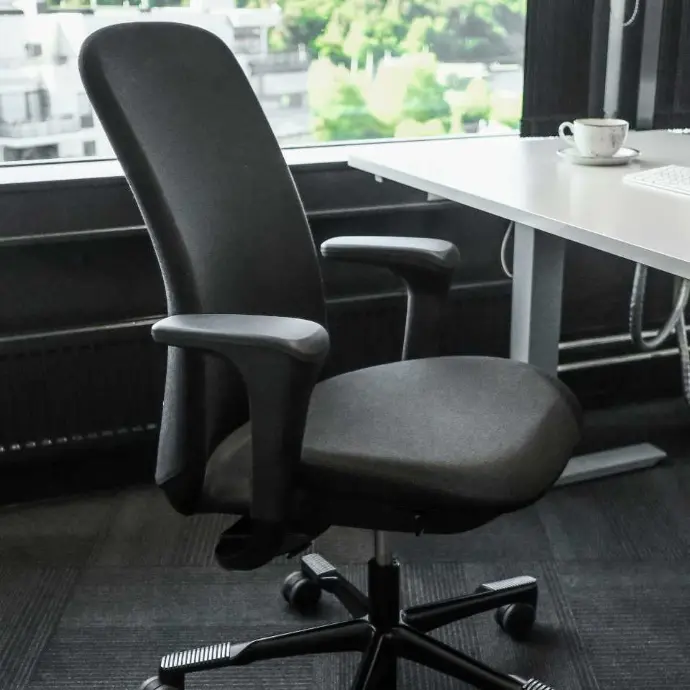 Black HÅG SoFi 7300 with fully upholstered backrest and armrests for long-lasting seating comfort Black HÅG SoFi 7300 office chair with armrests next to a desk