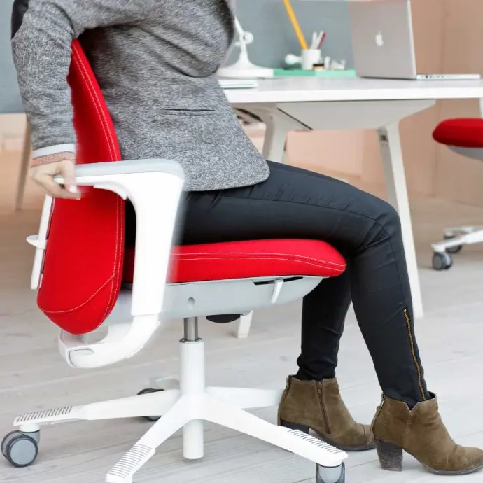 Detail of the HÅG SoFi 7300 with upholstered backrest, seat, and armrests for active sitting Close-up of a red HÅG SoFi 7300 with armrests and an upholstered seat