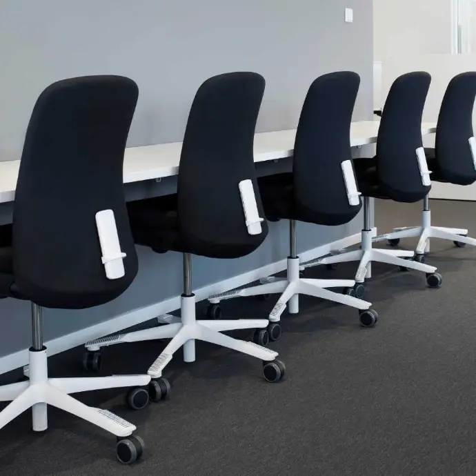 Black HÅG SoFi 7300 chairs with fully upholstered backrests for offices and shared workspaces Row of black HÅG SoFi 7300 office chairs at workstations